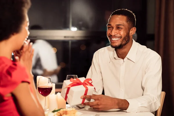 Afrikai amerikai férfi ajándékozás meglepett nő étteremben — Stock Fotó