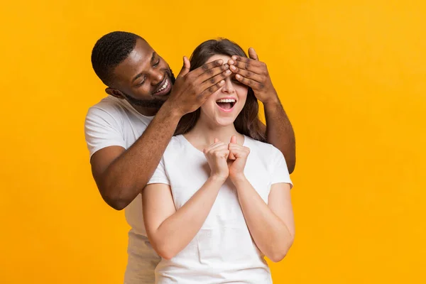 Juguetón negro chico sorprendiendo a su novia, cerrando los ojos con las manos —  Fotos de Stock