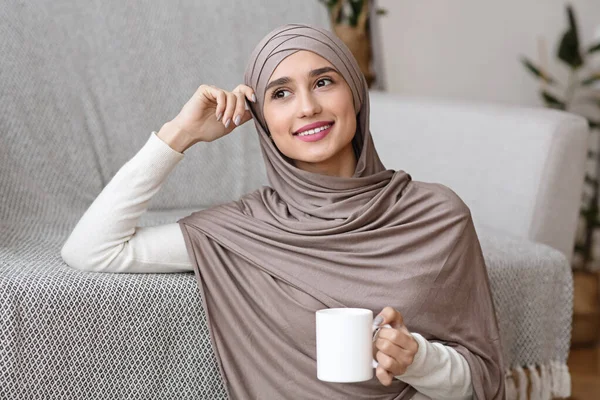 Pensive muslim gadis dalam hijab santai dengan teh di rumah — Stok Foto