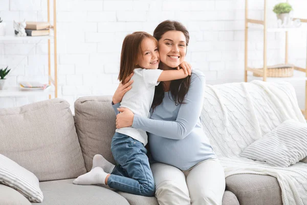 Esperando mãe e filha abraçando na sala de estar — Fotografia de Stock