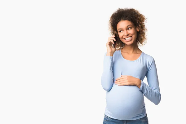 Телефонний дзвінок. Африкансько-американська вагітна жінка розмовляє по мобільному телефону — стокове фото
