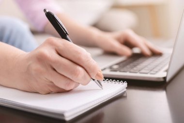 Üst düzey bayan laptop kullanarak internetten bilgi alıyor.
