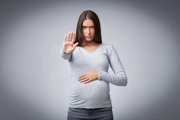 Mujer embarazada gesto dejar de prohibir o advertencia posando en el estudio — Foto de Stock