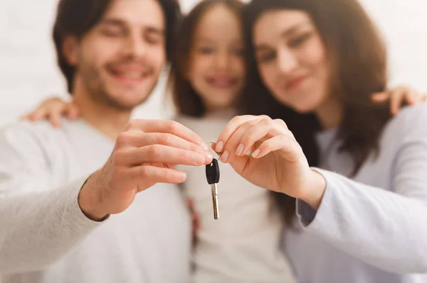 Pais felizes com a pequena filha segurando a chave de sua nova casa — Fotografia de Stock