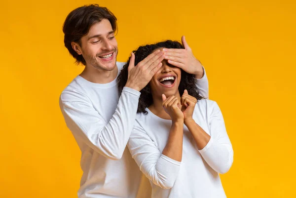 Loving Guy Covering ogen van zijn Afro vriendin, Verrassend haar — Stockfoto
