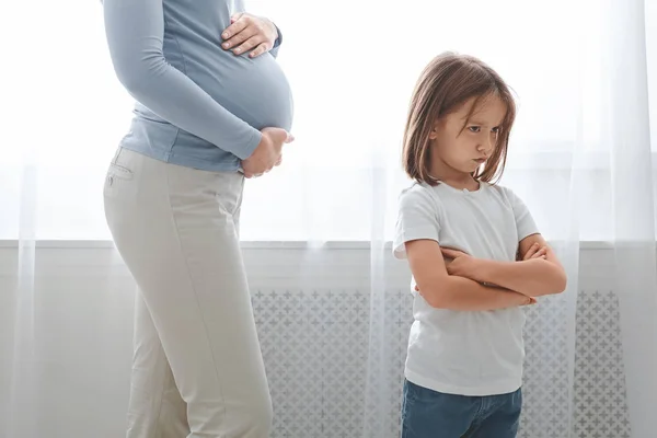 Sad little girl turning from her pregnant mother belly — 스톡 사진