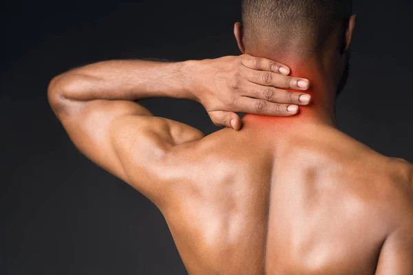 Unrecognizable shirtless afro guy suffering from pain in neck