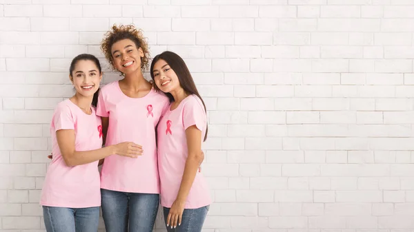 Three Girls In T-Shirts With Ribbons Standing Over White Wall — Stock Photo, Image
