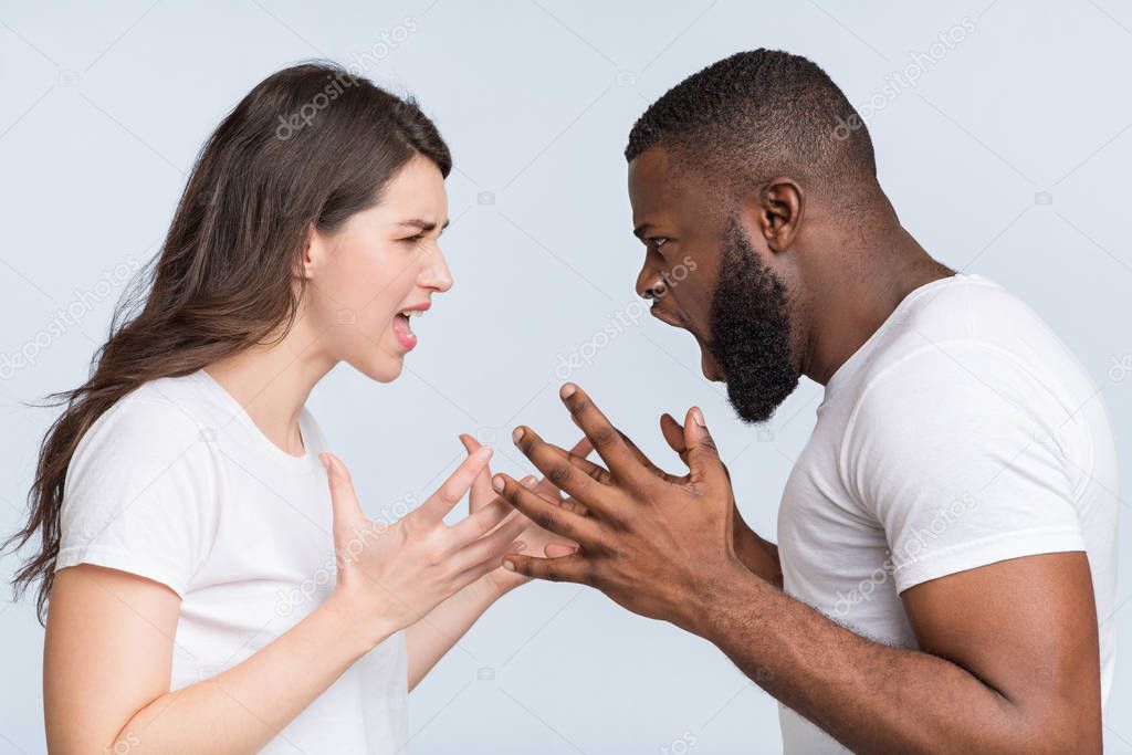Multiracial couple quarreling, shouting at each other, having relationship problems