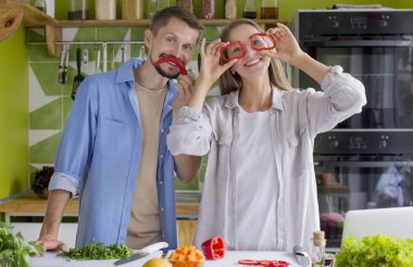 Genç çift vejetaryen salatası pişiriyor ve mutfakta eğleniyor.