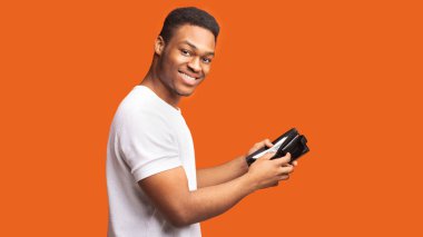 Cüzdanı parayla gösteren siyah adamın portresi.