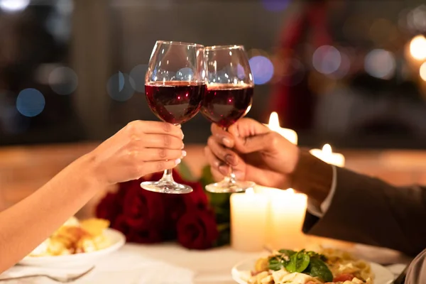 Verliebte Hände klirren Gläser beim Date im Restaurant — Stockfoto