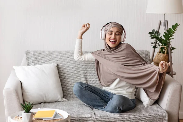Gadis Arab yang ceria dengan headphone nirkabel mendengarkan musik di rumah — Stok Foto