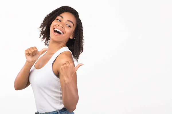 Menina africana apontando para o espaço livre com polegares para cima — Fotografia de Stock