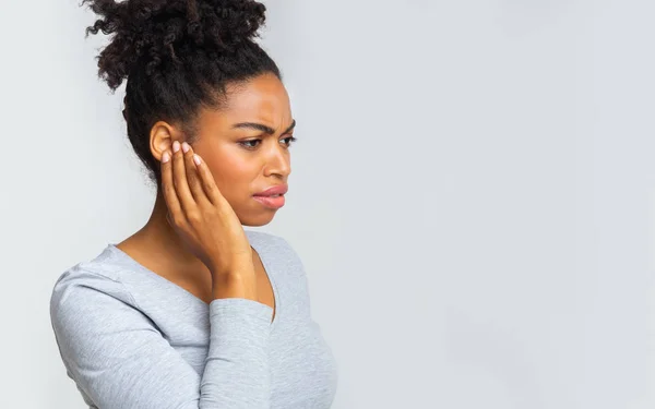 Afro menina que sofre de otite, esfregando seu ouvido inflamado — Fotografia de Stock