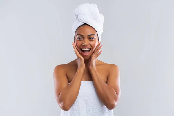 Excitada senhora negra envolta em toalha expressando espanto — Fotografia de Stock