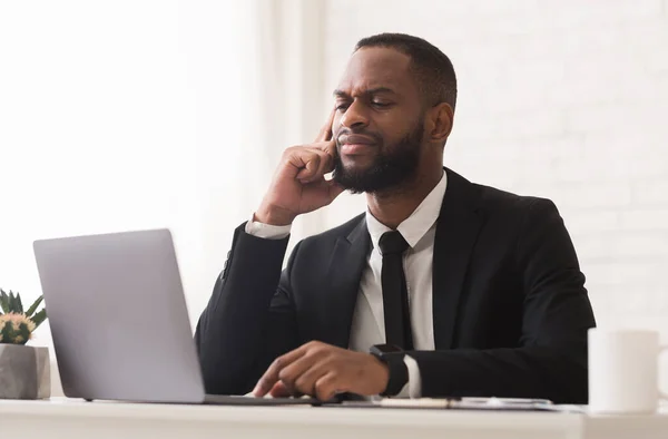 Pensive černý podnikatel pracující s notebookem v kanceláři — Stock fotografie