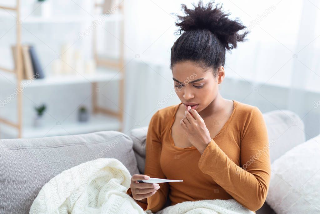 Lady Holding Thermometer Having Fever Sitting On Sofa At Home