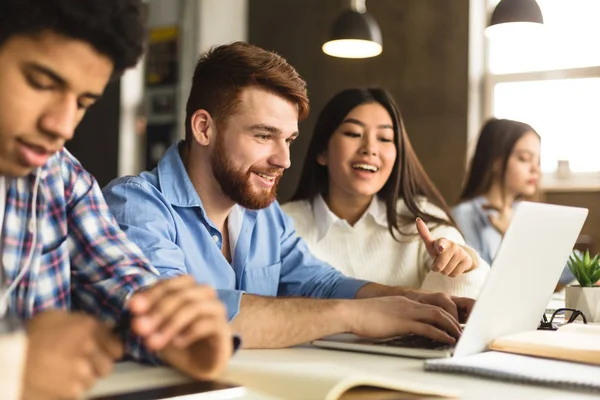 Smart college students networking on laptop in library — Stock Photo, Image