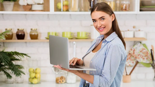 Szukam przepisu. Dziewczyna korzystająca z laptopa w kuchni — Zdjęcie stockowe