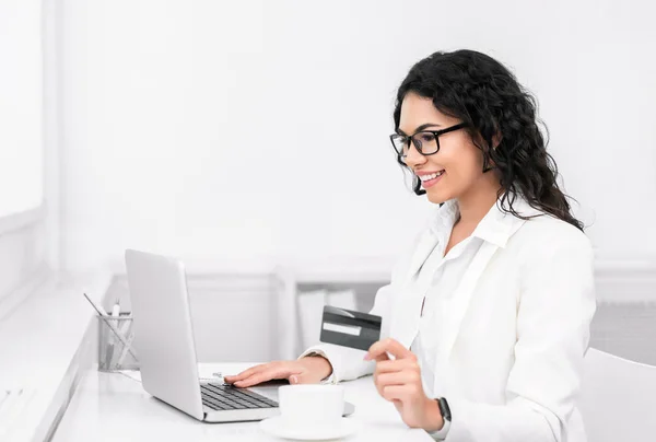 Latin woman holding credit card using laptop — 스톡 사진