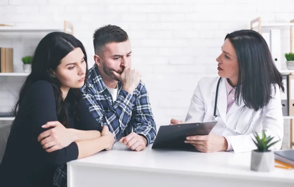 Cónyuges preocupados escuchando a los médicos cita médica — Foto de Stock