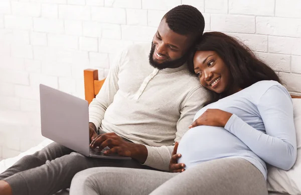 Lovely pregnant couple using laptop while resting — 스톡 사진