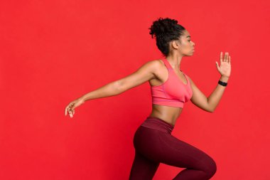 Spor giyim sektöründe koşan genç bir kadının yan görünüşü