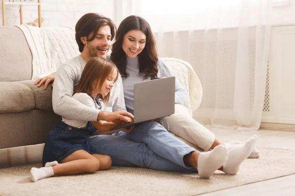 Famiglia felice con figlia che usa il computer portatile insieme a casa — Foto Stock