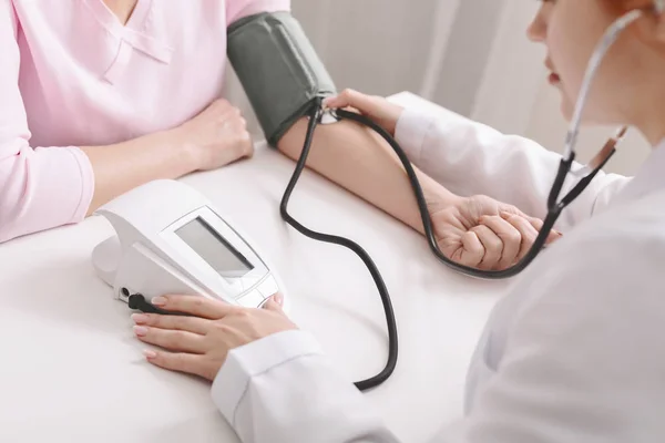 Tonometresi olan doktor kadının kan basıncını ölçüyor. — Stok fotoğraf