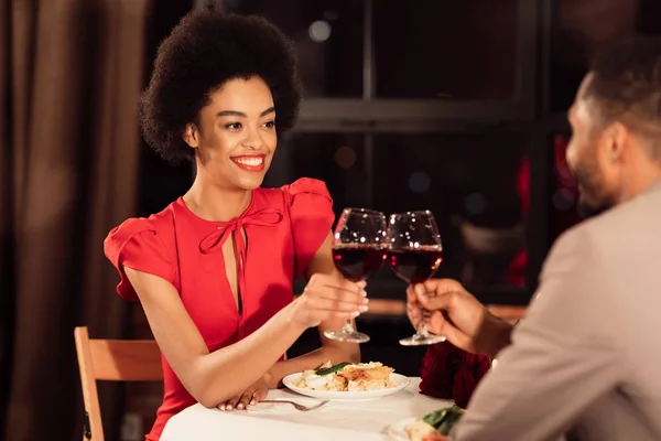 Joyeux couple afro-américain d'amoureux clinking lunettes dans le restaurant — Photo