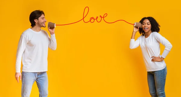 Mensaje de amor. Romántica pareja interracial hablando a través de estaño teléfono — Foto de Stock