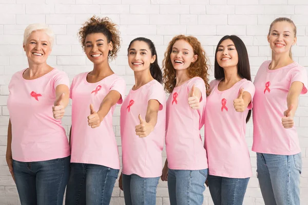 Dames met borstkanker linten Gesturing Duimen-Up Staande Over Wall — Stockfoto