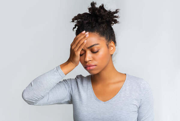 У больной чёрной девушки жар, она касается лба.
