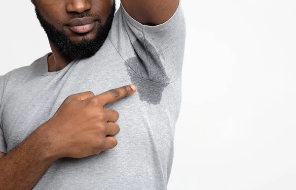 Молодий чорний чоловік дивиться на спітнілу сорочку — стокове фото