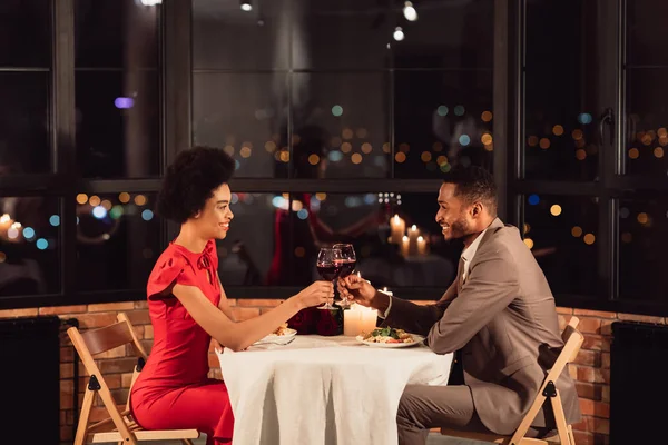 Paar klappert Gläser und trinkt Wein zum Valentinstag in Restaurant — Stockfoto