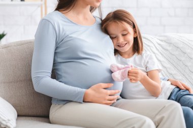 Bebek ayakkabılarıyla oynayan sevimli kıza yakın dur.