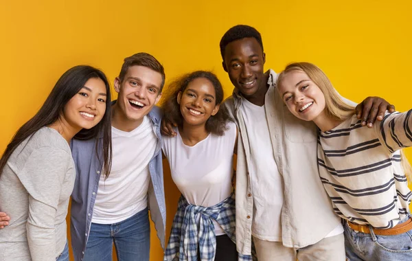 Estudantes internacionais amigáveis tirando selfie sobre fundo amarelo — Fotografia de Stock