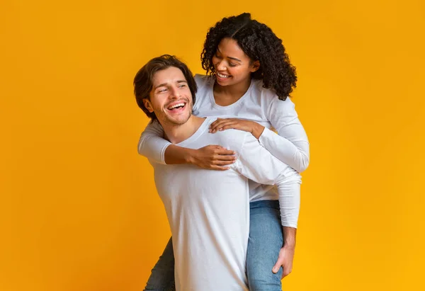 Älskade killen bär sin afro flickvän på rygg, ha kul tillsammans — Stockfoto
