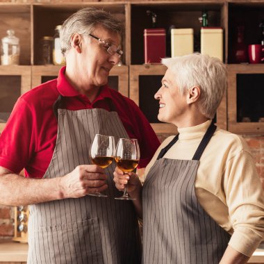 Mutfakta şarap bardakları ile yaşlı çift clinking