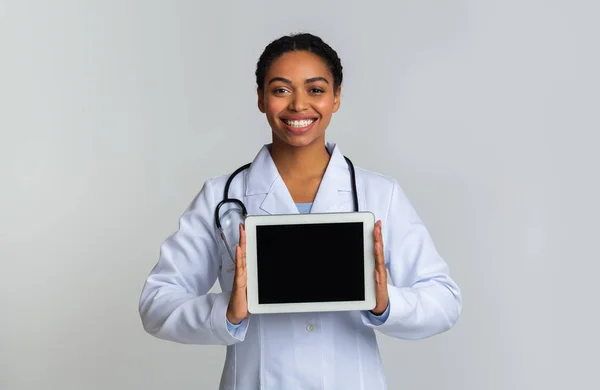Tabletka cyfrowa z czarnym ekranem w rękach Afro Kobieta lekarz — Zdjęcie stockowe