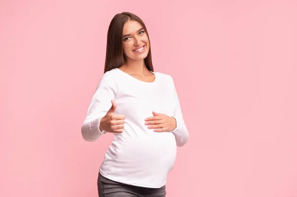 Pregnant Girl Gesturing Thumbs Up Approving Something, Studio Shot — Stock Photo, Image