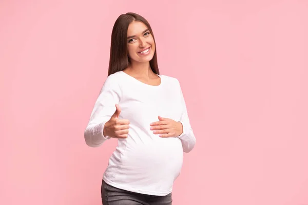 Hamil Girl Gesturing Thumbs Up Approving Something, Studio Shot — Stok Foto