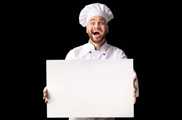 Возбужденный шеф-повар, держащий белую доску, стоящую в студии, макет — стоковое фото