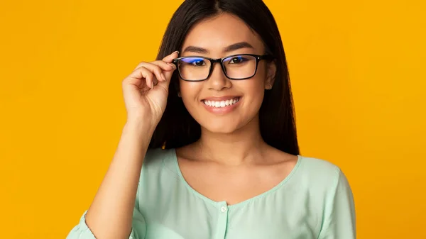 Magasin d'optique. heureux asiatique fille dans lunettes regarder caméra — Photo