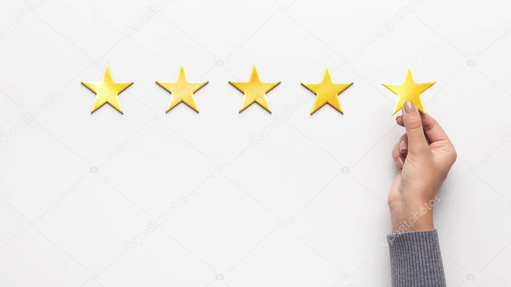 Woman hand point at five star rating on white