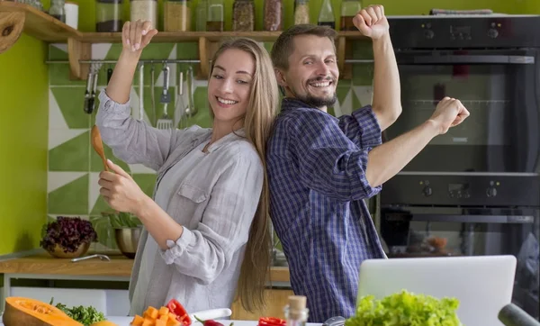 Millennial par dansar nära bordet med hälsosam mat i köket — Stockfoto