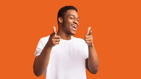Feliz chico afro eligiéndote sobre fondo naranja — Foto de Stock