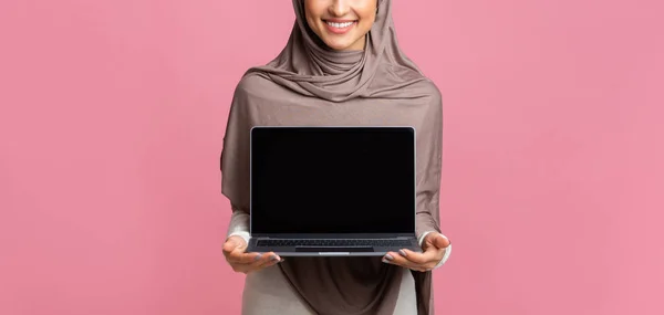 Muslim wanita dalam jilbab menunjukkan layar hitam komputer laptop — Stok Foto
