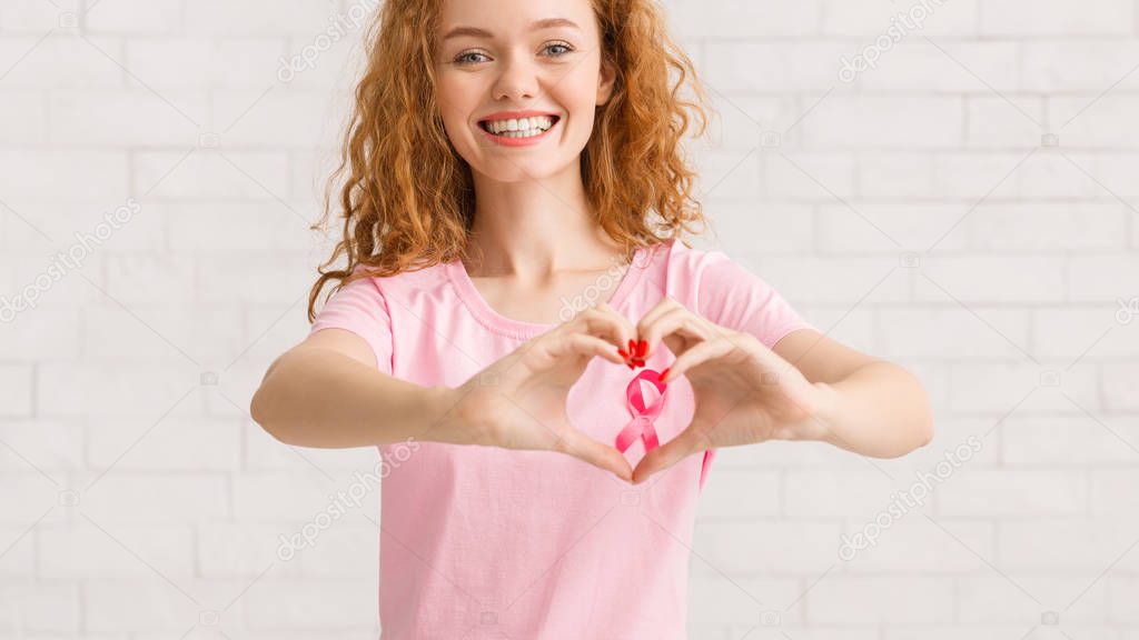 Girl Framing Pink Ribbon Forming Heart Shape From Hands, Panorama